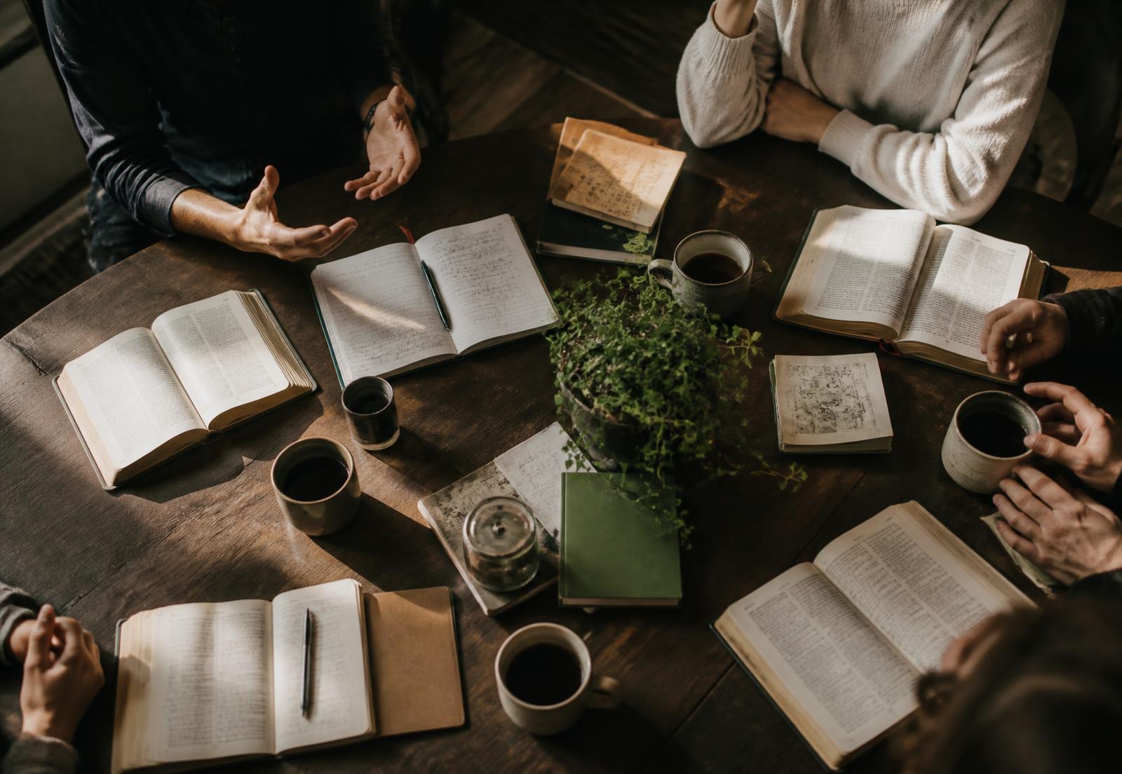 A group studying together around a table with open Bibles